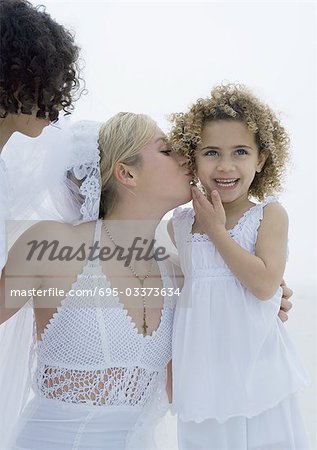 Bride kissing little girl's cheek