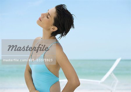 Femme sur la plage, la tête en arrière et les yeux fermés