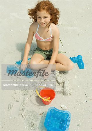 Girl playing in sand on beach
