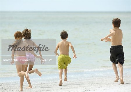 Enfants courir ensemble sur la plage