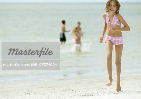 Girl running across beach