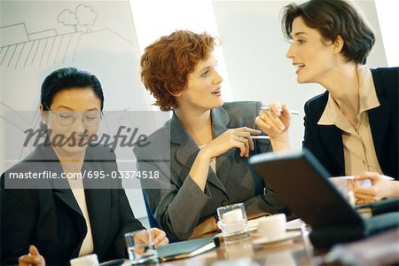 Three businesswoman sitting at table having meeting