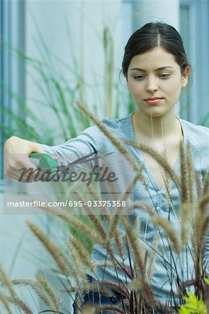 Young woman pruning bushes