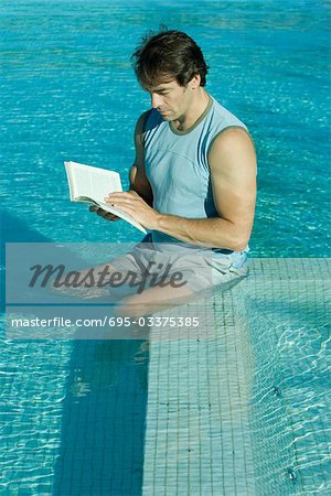 Man sitting in pool, reading