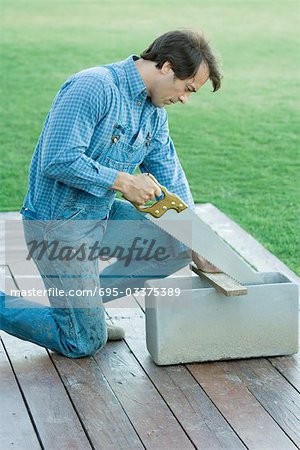 Man sawing piece of wood