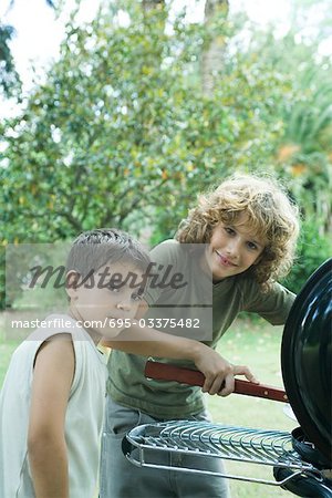 Deux garçons à barbecue, regardant la caméra