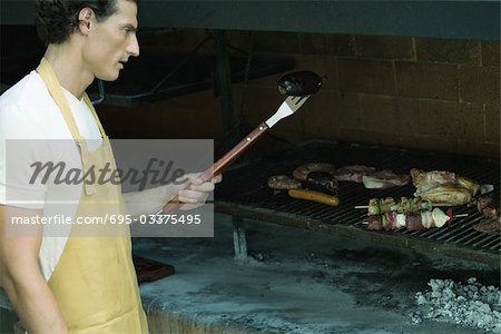 Mann Fleisch auf dem Grill Grillen