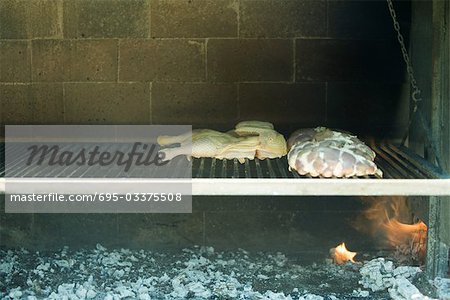 Meats grilling in wood oven