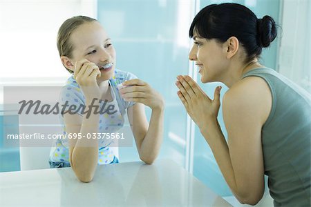 Mädchen essen Eis Dessert, Frau betrachten Mädchen mit Hände