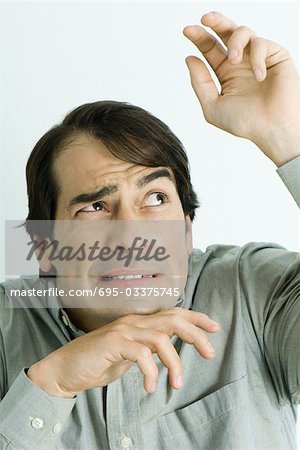 Man holding up hands, looking up, portrait