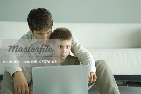Boy und Laptop zusammen mit Vater