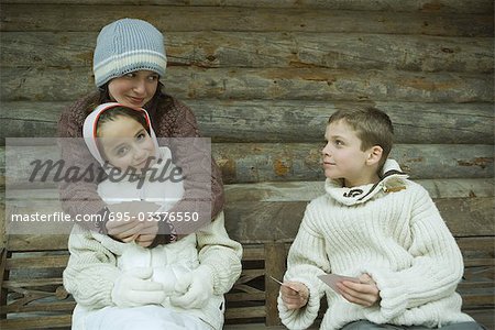 Young friends in winter clothes playing cards