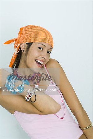 Teenage girl wearing lots of jewelry, smiling at camera, portrait