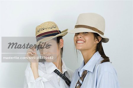 Deux jeunes amis portant chapeaux et cravates, souriant à la caméra, portrait