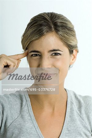 Femme tenant un doigt au temple, faire face, portrait