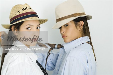 Deux jeunes amis face to face, aussi bien porter chapeaux et cravates, regardant la caméra