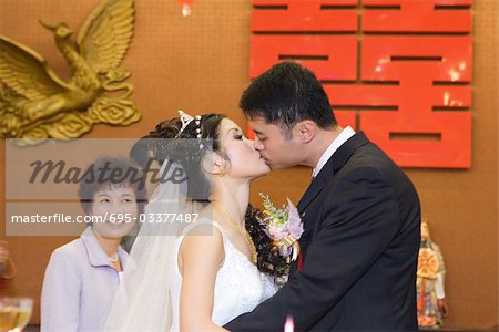 Bride and groom kissing, side view