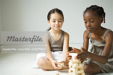 Zwei Mädchen sitzen auf dem Boden Stapeln Block