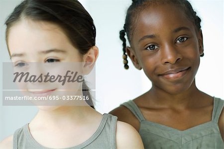 Two girls smiling, one looking at camera