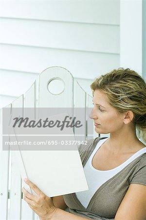 Femme assise sur un banc, livre de lecture, vue latérale