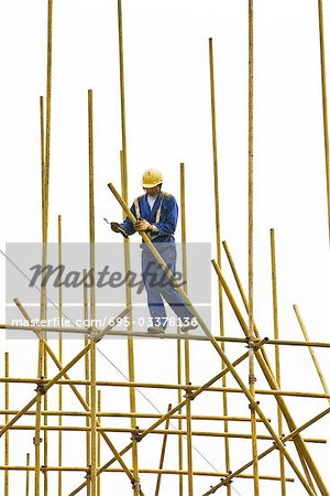 Man in hard hat assembling scaffolding