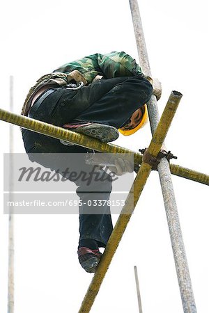 Construction worker on scaffolding, low angle view
