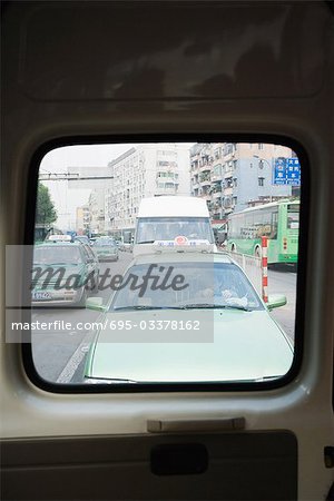 China, Guangzhou, Stadtverkehr, gesehen durch die hinteren Autofenster