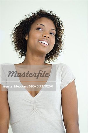 Jeune femme souriante, à côté de la taille vers le haut,