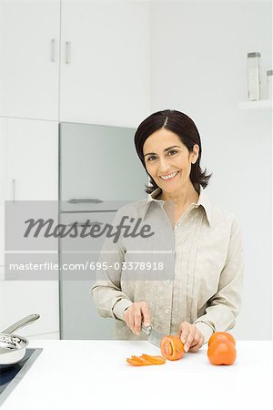 Woman slicing tomatoes in kitchen