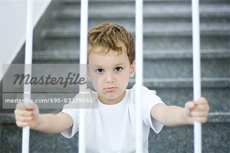 Kleiner Junge hinter Gittern, Blick in die Kamera