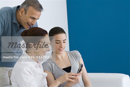 Familie Handy zusammen betrachten, Lächeln