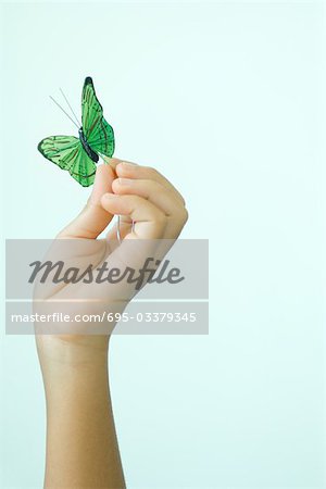 Papillon faux d'enfant main tenant