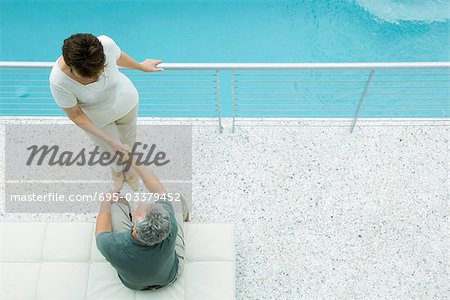 Couple on balcony, holding hands, high angle view