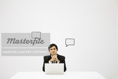 Businessman and word bubbles, looking at camera