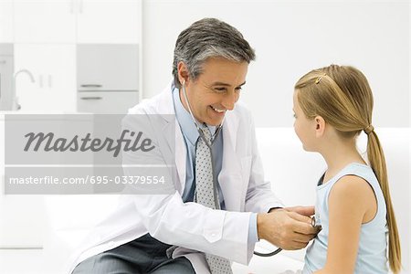 Médecin écoute au coeur de la fillette avec stéthoscope, souriant