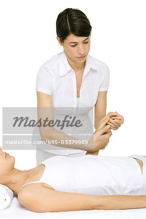 Massage therapist massaging woman's hand