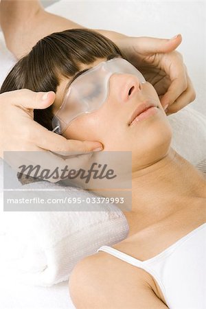 Femme recevant le massage du visage, masque d'oeil