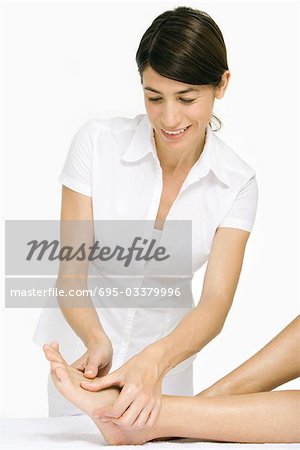 Massage therapist performing foot massage