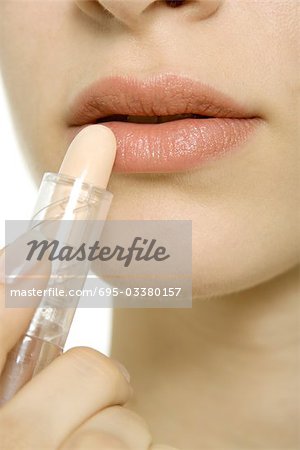 Woman applying lipstick, extreme close-up