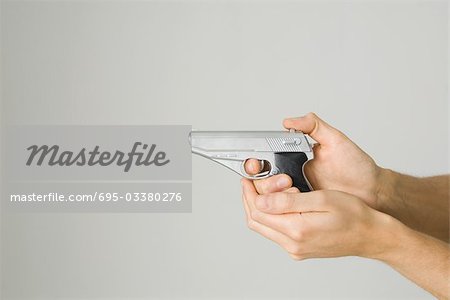 Hands holding and aiming toy gun, side view