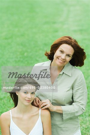 Mère avec sa fille adolescente, les deux regardant la caméra, sourire, portrait