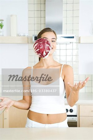 Woman with head of radicchio chicory falling in front of her face