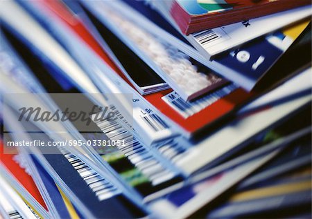 Disorderly stack of magazines, extreme close-up on corners with barcodes, full frame