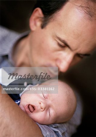 Man holding et regardant vers le bas de bébé qui dort, se concentrer sur le bébé, les yeux fermés et bouche ouverte, gros plan