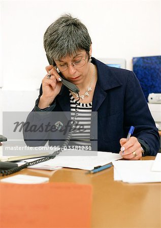 Femme assise au bureau, téléphoner