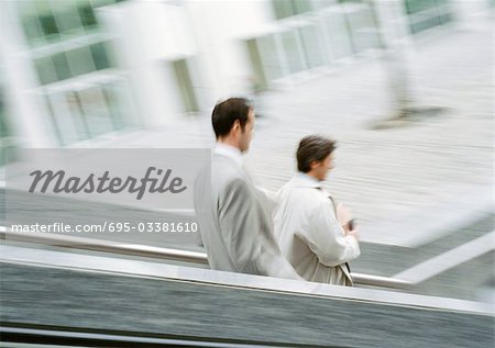 Two businessmen on stairs outside, blurred
