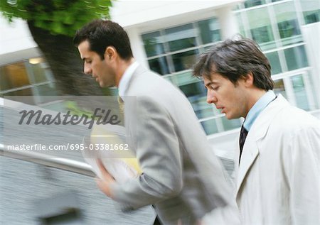 Two businessmen walking up stairs, upper section,  blurred