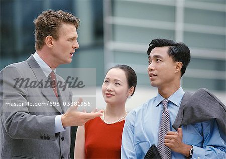 Business associates having discussion, one gesturing with hand