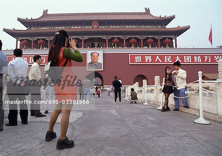 China, Beijing, woman taking photograph of gate leading to the Forbidden City