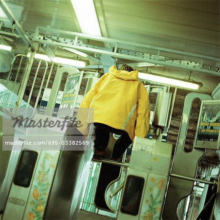 Young man jumping over turnstile in subway